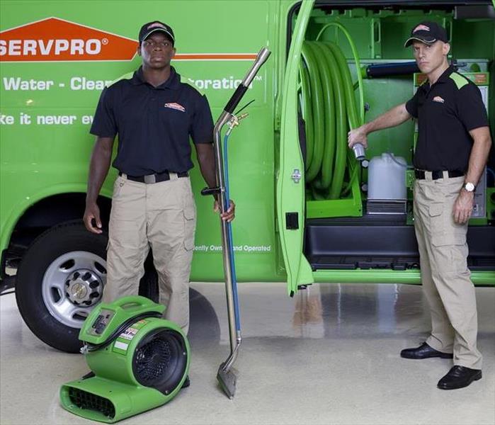 Two SERVPRO employees standing outside the SERVPRO van