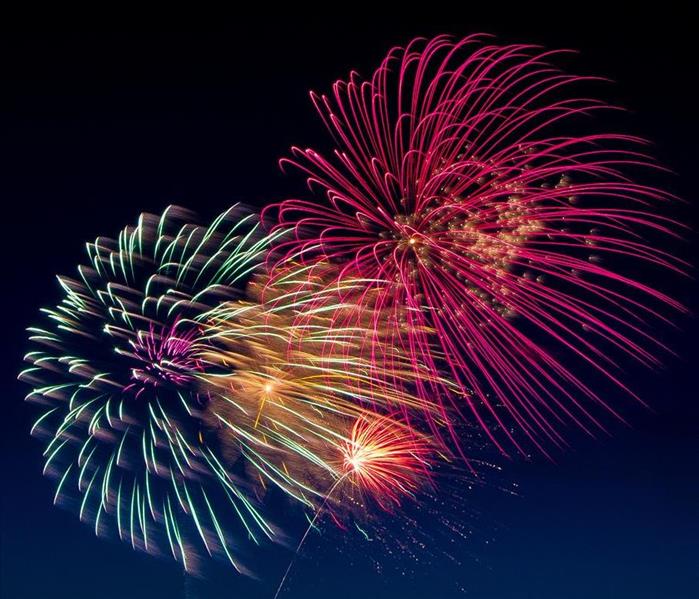 Fireworks of red, yellow, orange, green, and purple in the night sky.